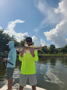 Reeling in a redfish while jigging in Milton's partly cloudy skies!