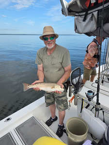 Reeling in a redfish on a clear day in Milton - that's fishing at its best!