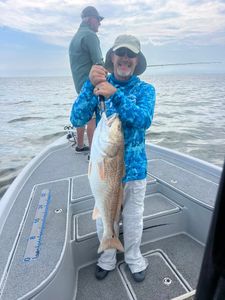 A pair of anglers reeling in a Redfish in Venice