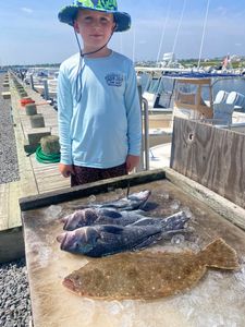 Angler holding two huge summer flounder in New Jersey