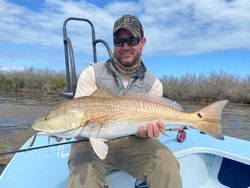 Angler holding large redfish on fishing boat in Welches OR