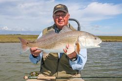 Angler holding large redfish caught while fishing in Welches OR