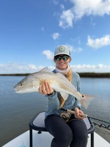 Angler holding caught redfish on boat in Welches OR waters