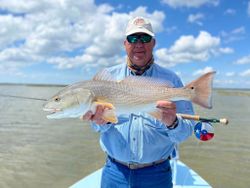 Angler holding large redfish catch on fishing boat in Welches OR