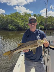 Angler holding caught snook on fishing boat in Fort Myers FL waters