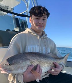 A fisherman holding a redfish catch in Florida