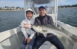 A pair of anglers fishing for striped bass in MA