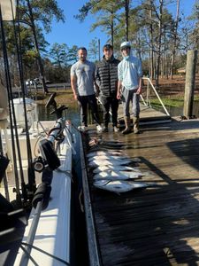 Three people fishing on the shore in SC