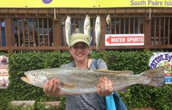 Two people fishing with their haul of 3 fish in Port Isabel