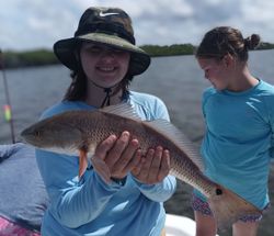 Two people fishing for a redfish in Weeki Wachee