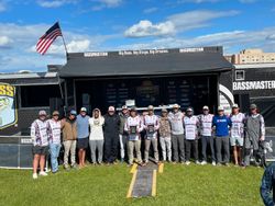 Bass fishing tournament awards ceremony at outdoor event in Fort Worth TX with Bassmaster signage and American flag