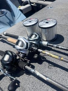 Fishing reels and rods with fluorocarbon line spools laid out on boat deck in Fort Worth TX