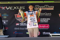 Angler displaying two smallmouth bass at fishing tournament weigh-in in Fort Worth TX
