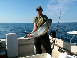 A fisherman with a large fish caught in NY