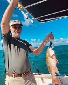 A fisherman holding a Mutton Snapper in Key Largo