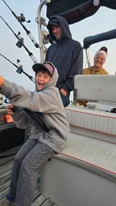 Three people fishing on the water in MI