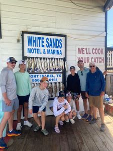 A group of 8 people fishing at Port Isabel