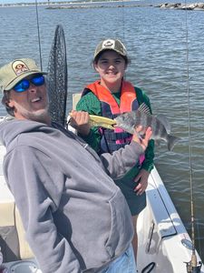 Angler with a black drum fish in Pass Christian