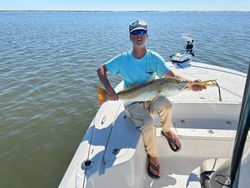 A fisherman holding a large redfish in Pass Christian