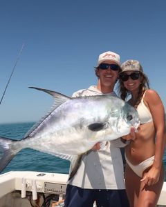 A permit fish being held by two people in Holmes Beach