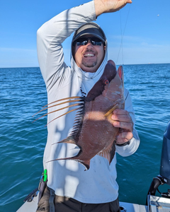 A fisherman casting a line in the waters of Holmes Beach
