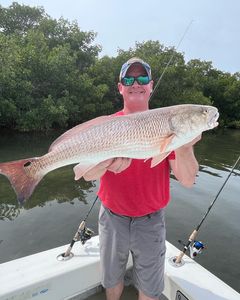 Fisherman holding a big redfish in Holmes Beach