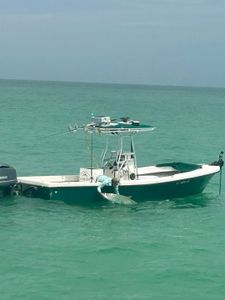 Fishing boat with tarpon caught alongside in turquoise waters near Holmes Beach FL