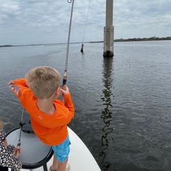 Young angler fishing from boat with rod over water near wooden posts in Palmetto FL