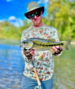 A fisherman holding a spotted bass in AR.