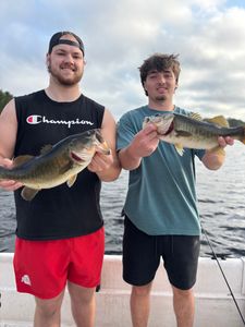 Two anglers displaying freshly caught bass while fishing in Interlachen FL
