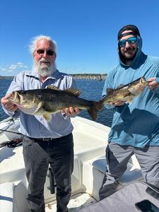 Two anglers displaying their bass catch on a fishing boat in Interlachen FL