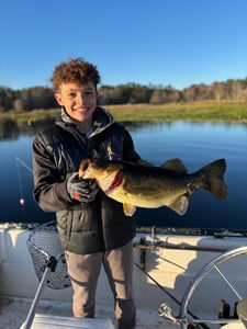 Happy young angler with a bass