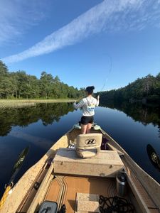 Fishing guide casting line from boat dock in South Portland Maine