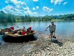Fishing guide launching drift boat on river in South Portland Maine for guided fishing tour