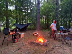 Upside down view of fishing camp with suspended equipment and campfire in South Portland ME forest