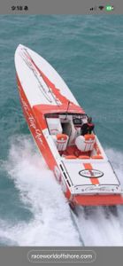 Red and white offshore powerboat racing through turquoise waters in St. Petersburg FL creating white wake spray