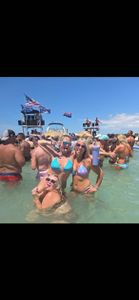 Group enjoying water sports activities in clear blue waters near St. Petersburg FL with boats and flags visible