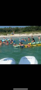Group enjoying water activities with kayaks and floating in clear turquoise waters near beach in St. Petersburg FL
