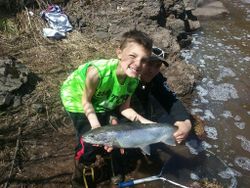 A person fishing for a single rainbow trout in Wisconsin
