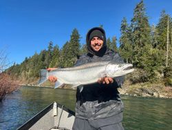 Angler holding large salmon caught while fishing from boat in Gold Beach OR