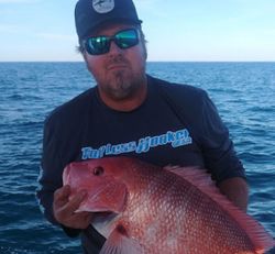 A fisherman holding a 16-inch fish in FL