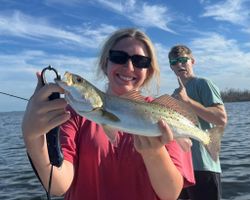 A fisherman reeling in a spotted weakfish in Cape Coral