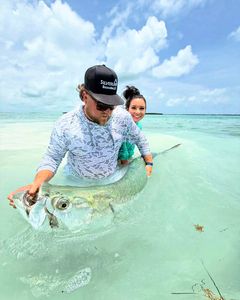 Two anglers holding fishing rods on the shore in FL
