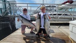 Anglers with 3 large bull and rainbow trout caught fishing in Milwaukee