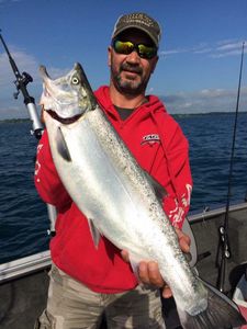 A fisherman holding a large rainbow trout in Sheboygan