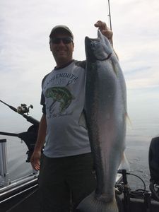 Angler reeling in a large rainbow trout in Sheboygan