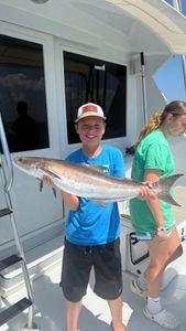 A picture of two anglers fishing for a cobia in Cape Charles