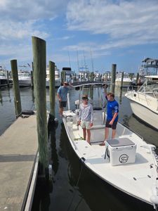 Three anglers posing with their catch in a scenic location in MS