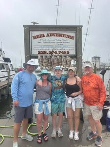 Fishing charter group displays caught fish at marina dock in Gulfport MS