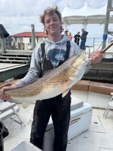 Two people fishing in Gulfport with a 24-inch catch